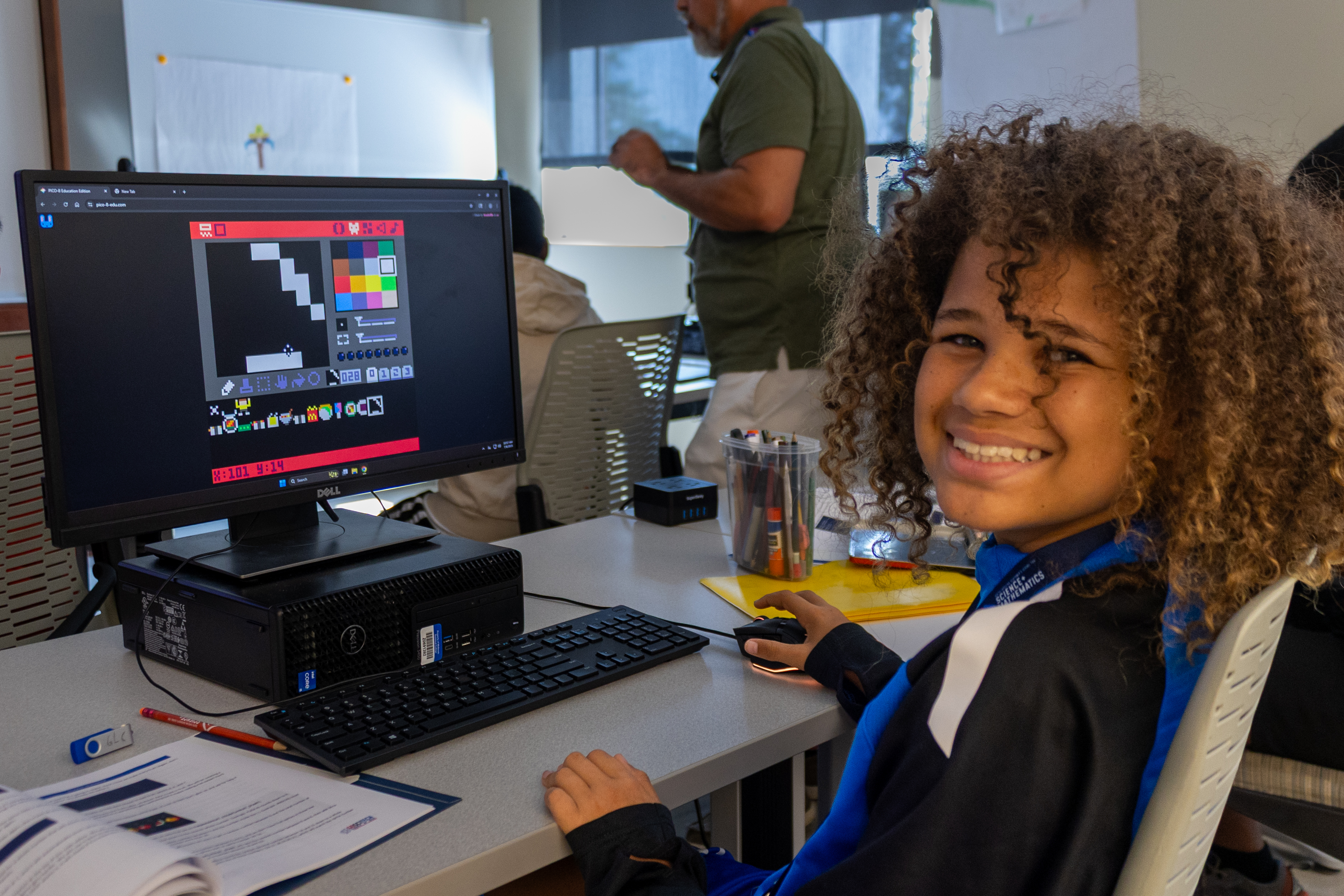 photo of student smiling while working at a computer