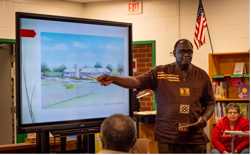 Photo of man pointing to architectural rendering