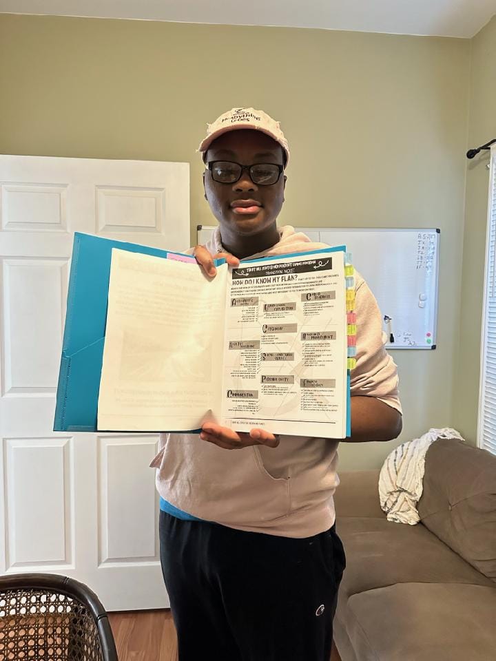 photo of student holding up school work