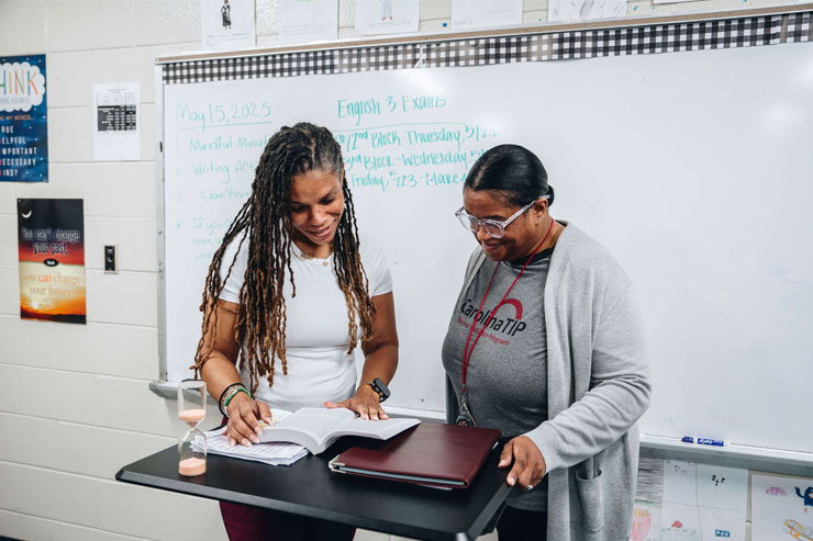 Photo of two women collaborating in a classroom, one wearing a Carolina TIP shirt