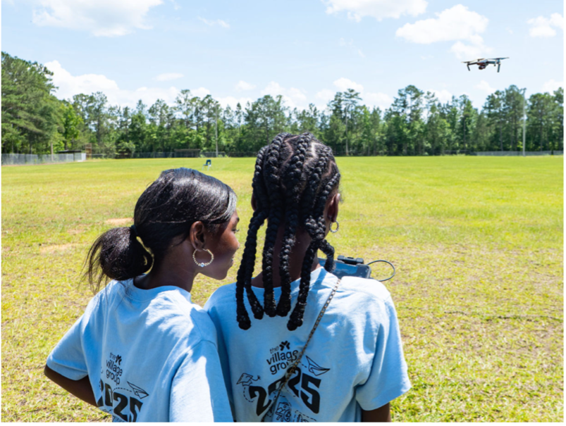 two girls flying a drone