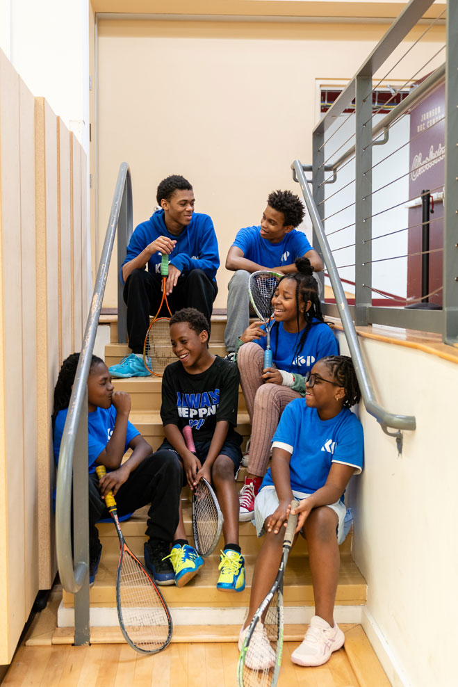 students hanging out on stairs after playing squash