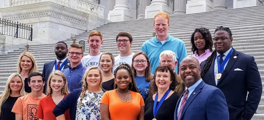 Group of Students in Action in D.C. national ceremony posing for a photo on the steps at Capitol Hill.