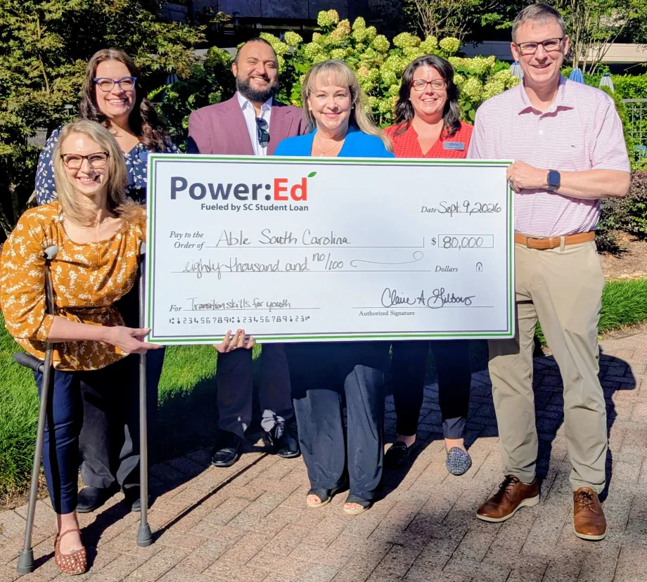 Executives pose with ceremonial big check