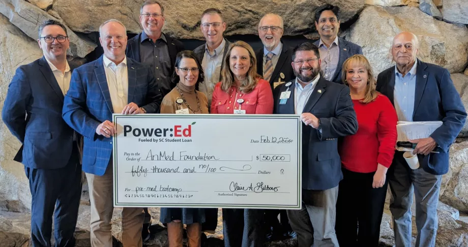 Executives pose with ceremonial big check