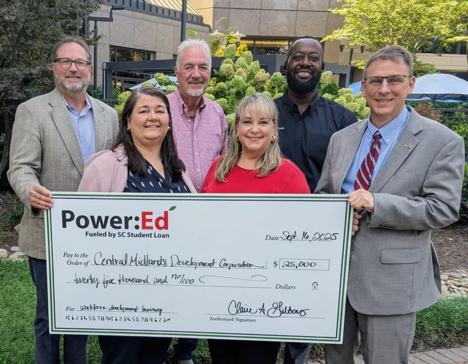 Executives pose with ceremonial big check