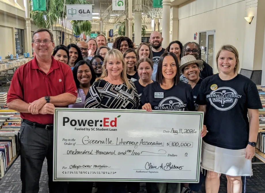 Executives pose with ceremonial big check
