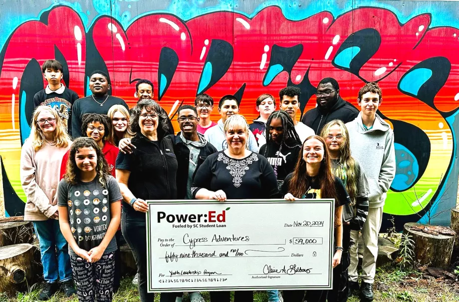 Students and adults pose with big ceremonial check
