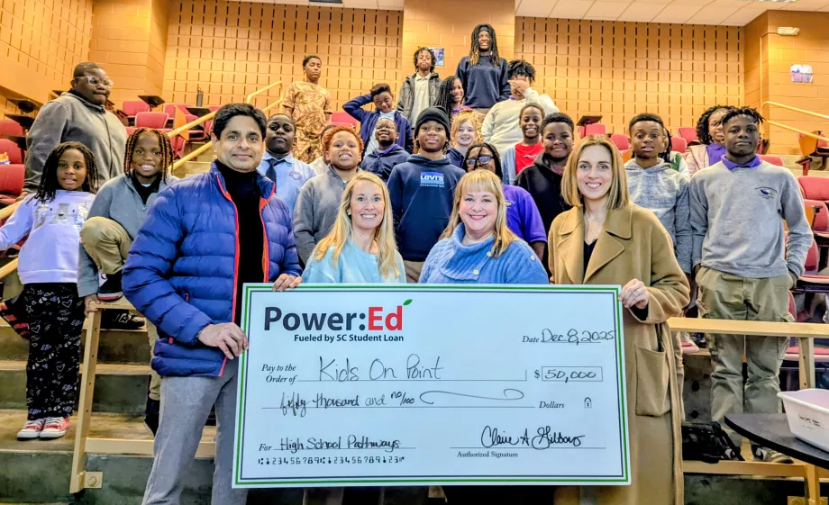Students and adults pose with big ceremonial check