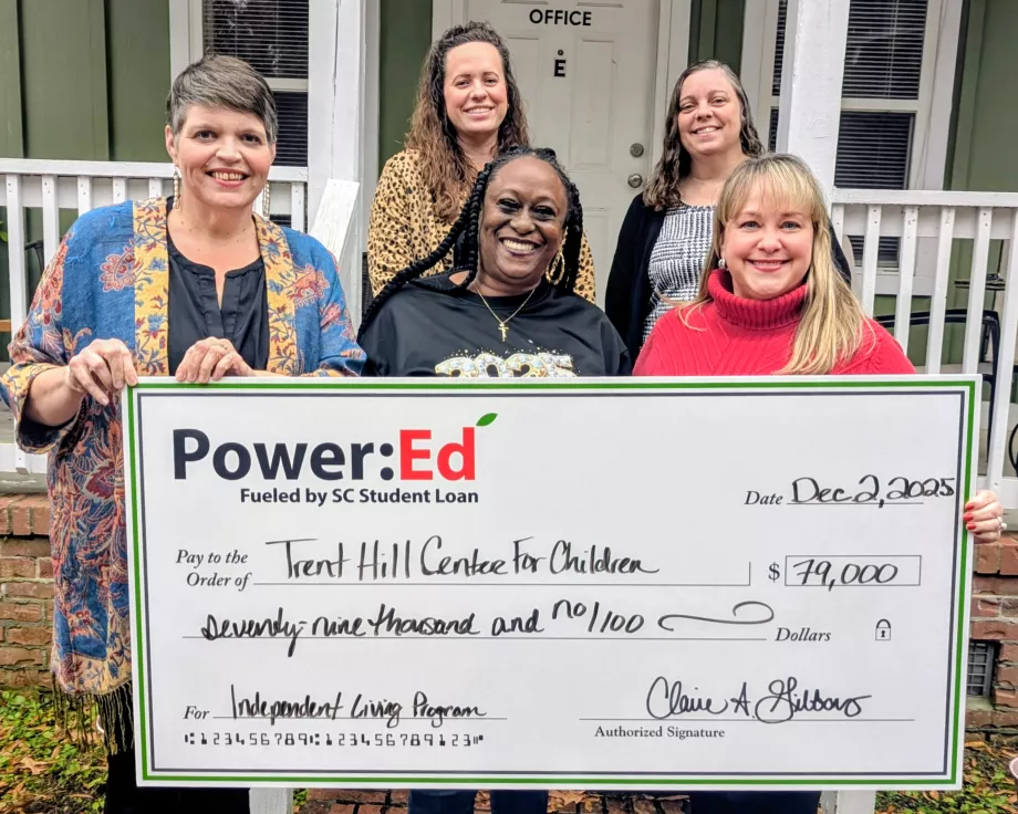 Women pose with ceremonial big check