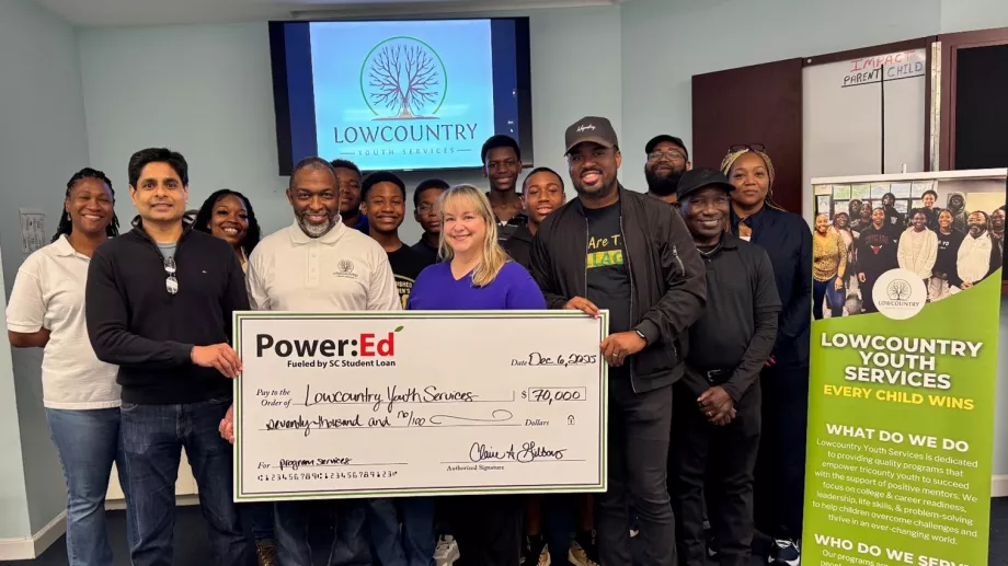 Students and adults pose with big ceremonial check