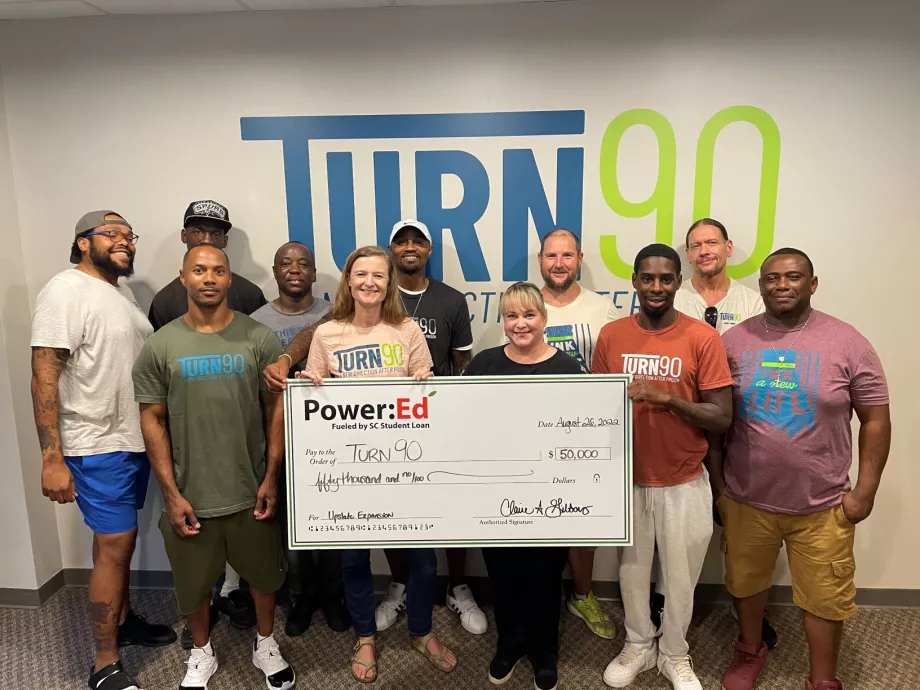 People pose with ceremonial check