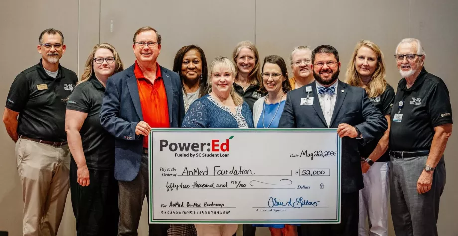 Executives pose with ceremonial big check