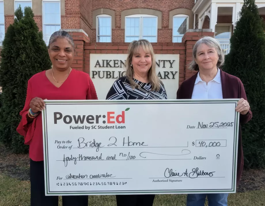 Women pose with ceremonial big check