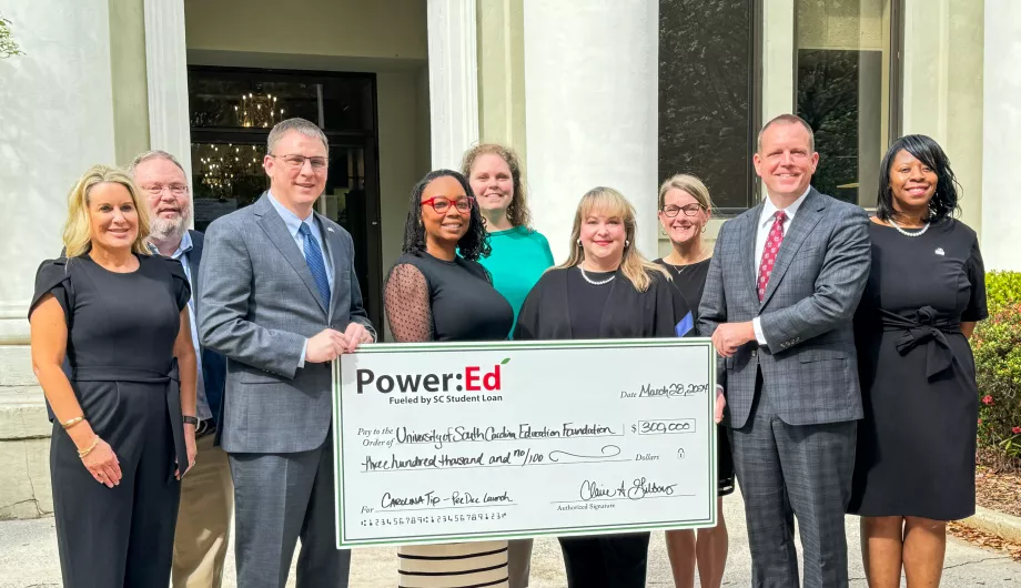 Executives pose with ceremonial check