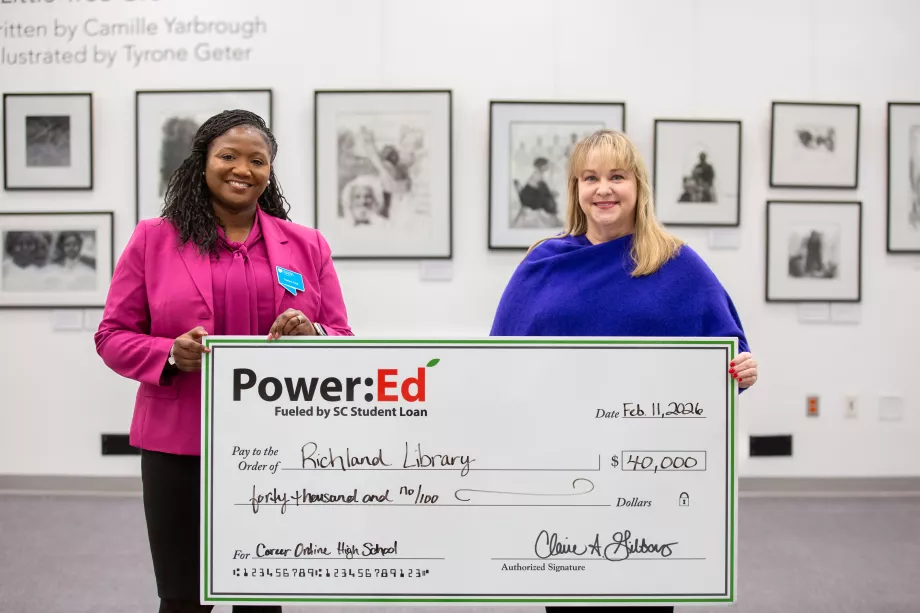 Executives pose with ceremonial big check
