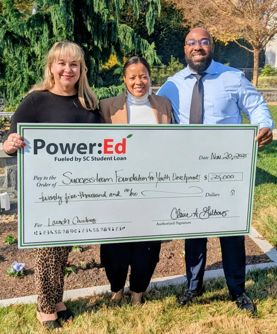 Executives pose with ceremonial big check