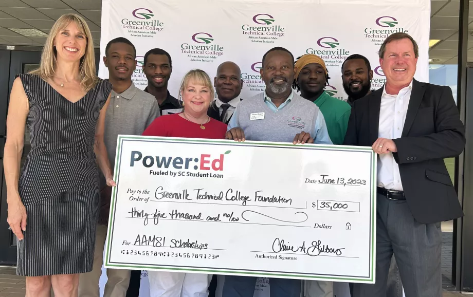 People pose with ceremonial check