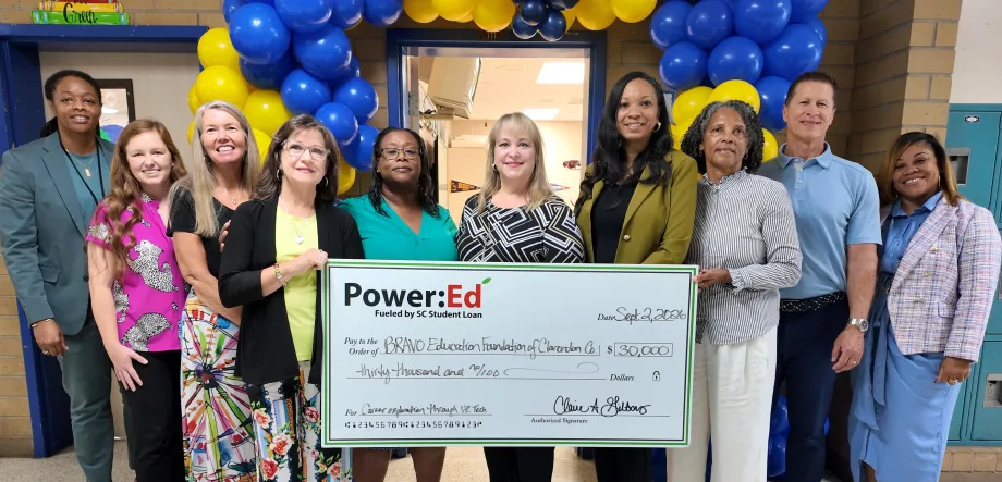Adults pose with ceremonial big check