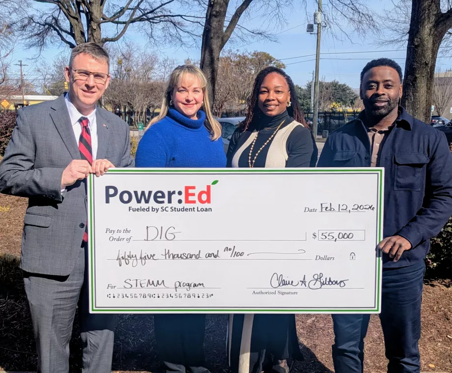 Executives pose with ceremonial big check