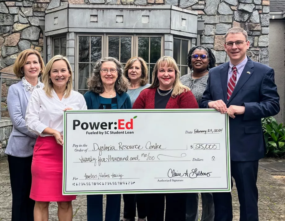 Executives pose with ceremonial big check