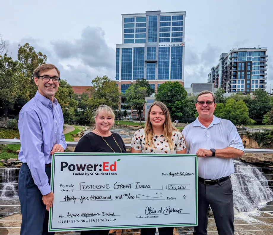 Executives pose with ceremonial check