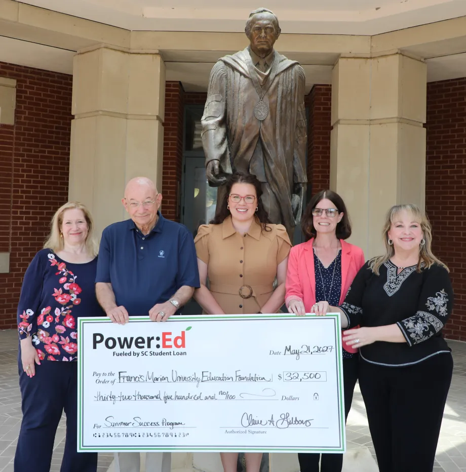 Executives pose with ceremonial big check