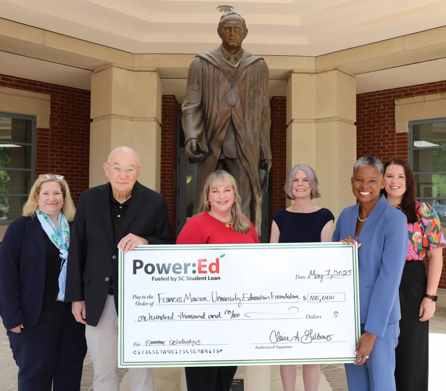 Executives pose with ceremonial big check