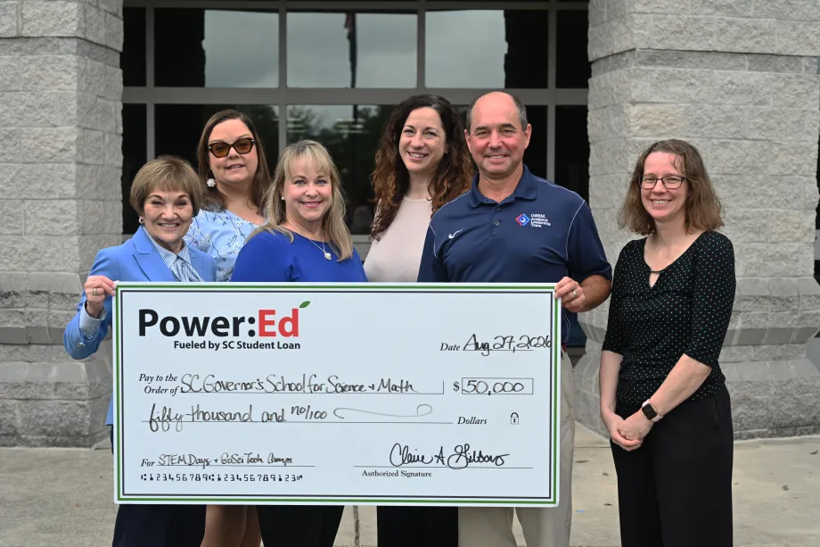 Executives pose with ceremonial big check