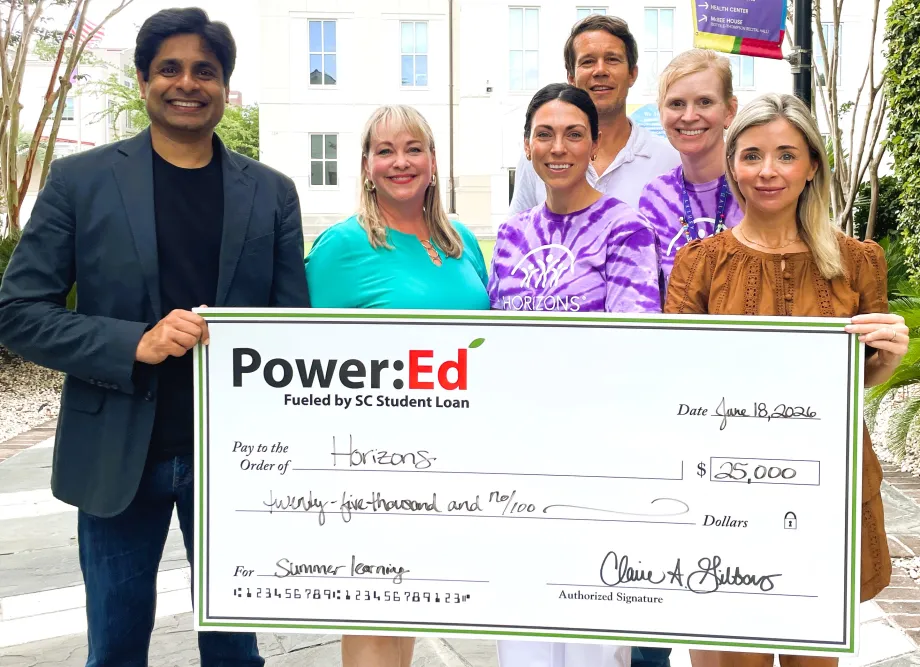 Executives pose with ceremonial big check