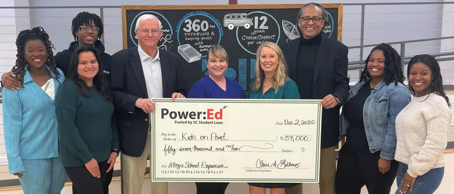 People pose with ceremonial check