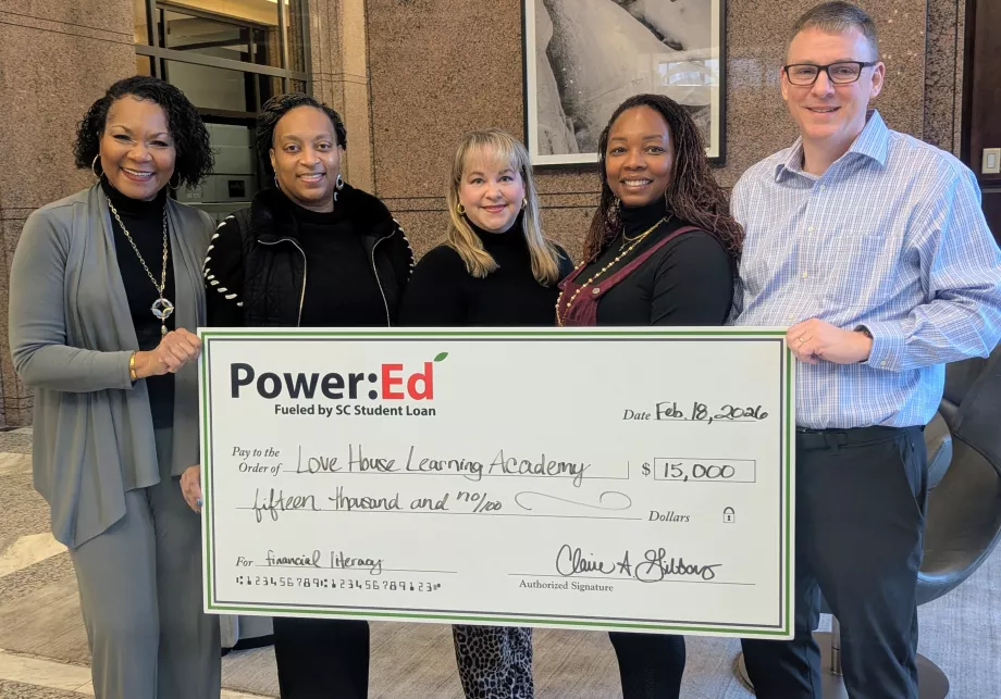 Executives pose with ceremonial big check