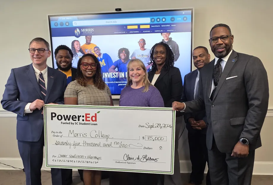 Executives pose with ceremonial big check