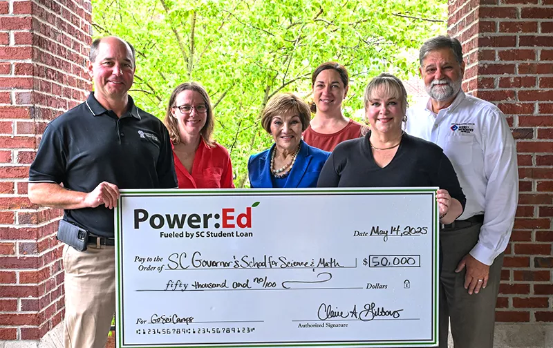 Executives pose with ceremonial big check