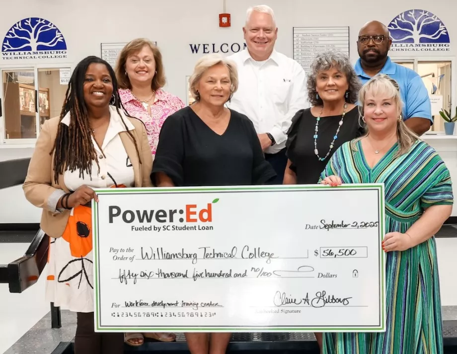 Executives pose with ceremonial big check