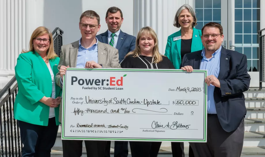 People pose with ceremonial big check