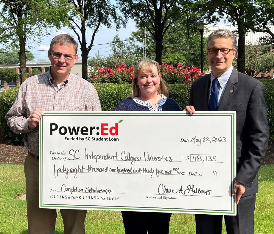 Executives pose with ceremonial check