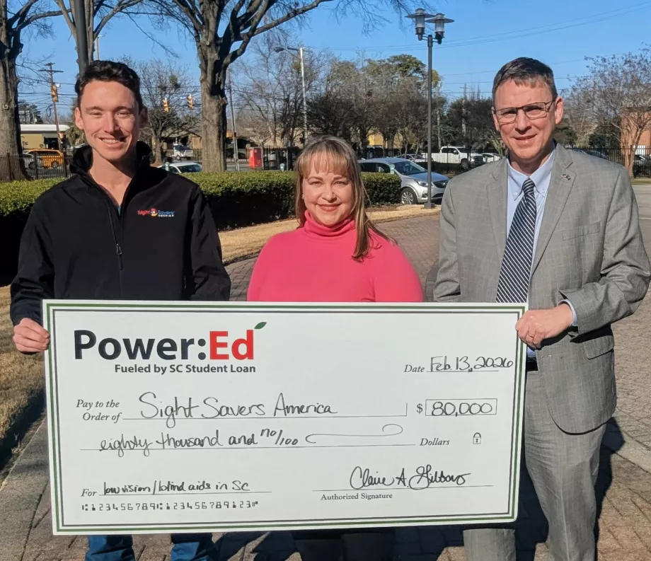 Executives pose with ceremonial big check