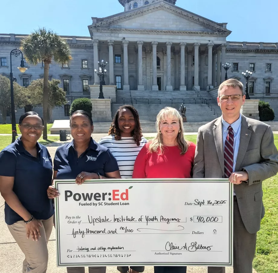 Executives pose with ceremonial big check