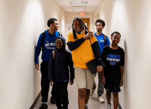 Photo of school-aged children walking down school hallway and smiling